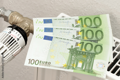 300 euros lie on the heating radiator. Three paper banknotes of 100 euros each. A symbol of rising heating costs. Money to pay the bills. Financial help, energy package. Energy relief paymen.
