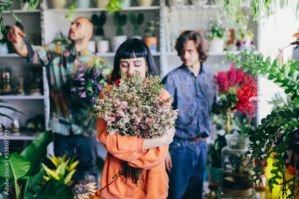 Woman working with florists in flower store