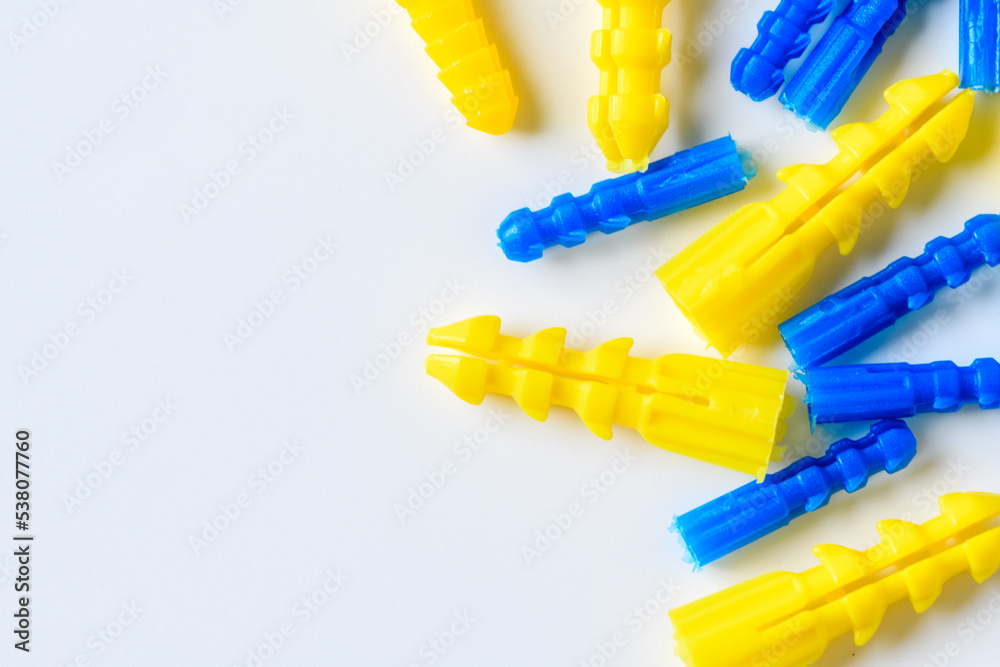 Yellow and blue plastic anchor on white background, Handyman Tools Yellow and blue plastic anchor on white background, Handyman Tools