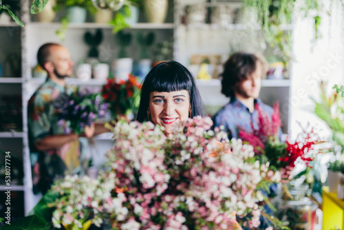 Woman working with florists in flower store