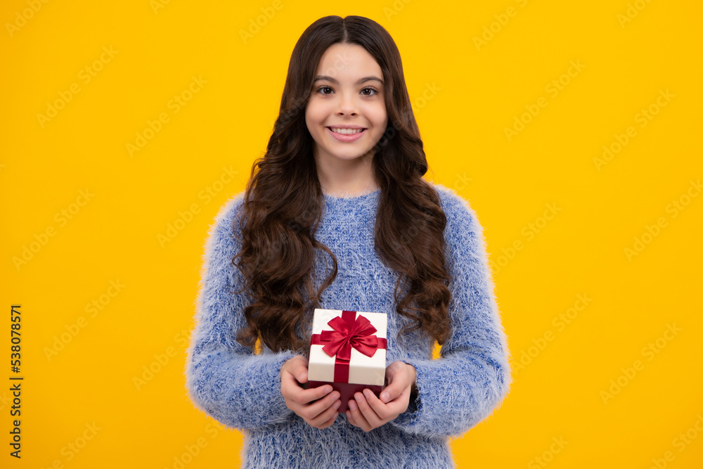 Funny kid girl in winter wear holding gift boxes celebrating happy New Year or Christmas. Winter holiday. Happy teenager, positive and smiling emotions of teen girl. Funny kid girl in winter wear holding gift boxes celebrating happy New Year or Christmas. Winter holiday. Happy teenager, positive and smiling emotions of teen girl.