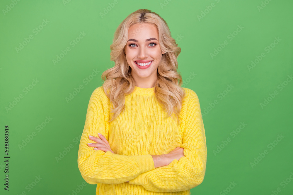 Photo of optimistic millennial blond lady crossed arms wear yellow sweater isolated on green color background Photo of optimistic millennial blond lady crossed arms wear yellow sweater isolated on green color background