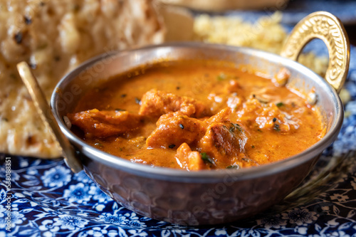 Indian style food, chiken tikka masala curry dish served with rice and garlic bread naan