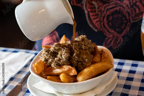 Scottish traditional snack food, hand cut potato chips topped with haggis and gravy photo