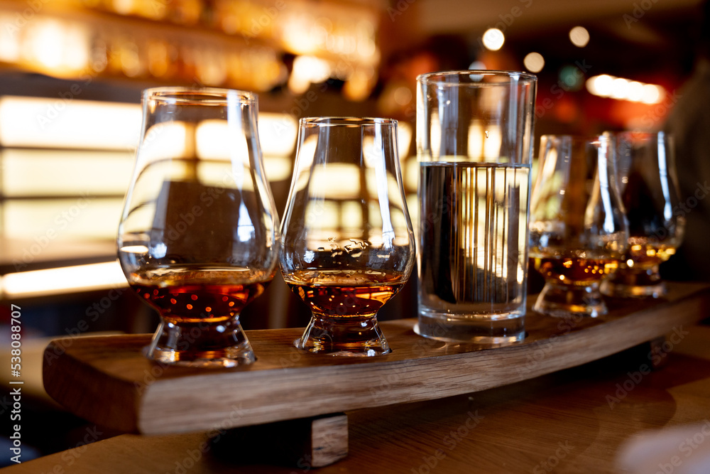 Flight of single malt scotch whisky in glasses served in whiskey bar in Edinburgh, UK