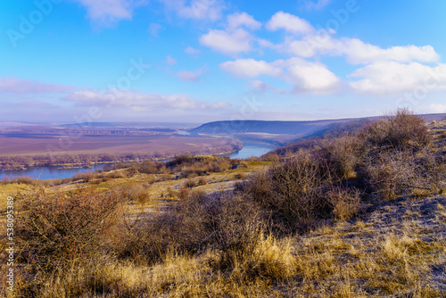 Beautiful view of the hilly valley with the river soothing winter nature. Background with copy space