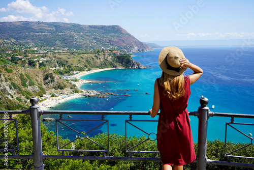 Traveling in Italy. Panoramic view of elegant woman with hat in Capo Vaticano in the Coast of the Gods, Calabria, Italy. photo