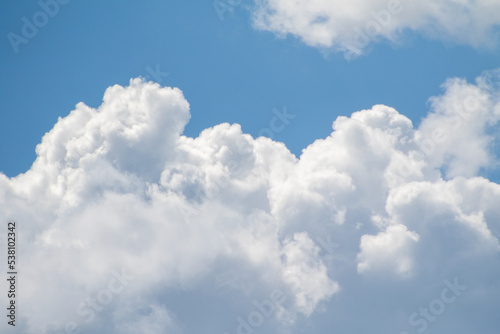 White clouds on the blue sky, bright background of the summer sky.