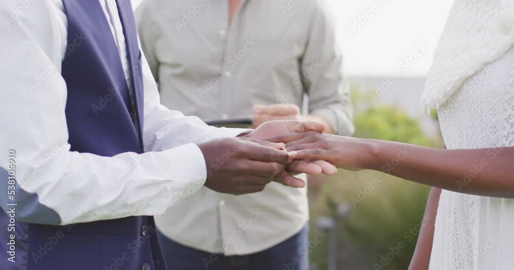 African american couple holding hands and putting ring during wedding African american couple holding hands and putting ring during wedding