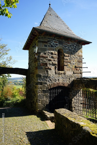 Alter Wehrturm mit Eingangsportal der Burgruine Staufenberg vor blauem Himmel im Sonnenschein im Herbst in Staufenberg im Kreis Gießen in Hessen photo