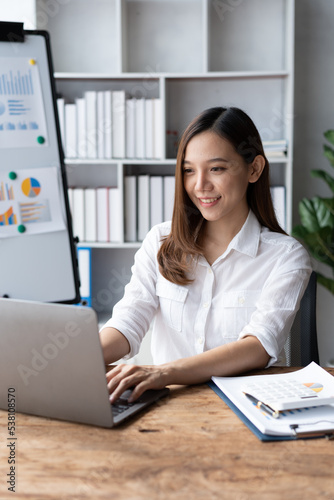 Portrait of an Asian young business Female working on a laptop computer in her workstation.Business people employee freelance online report marketing e-commerce telemarketing concept.