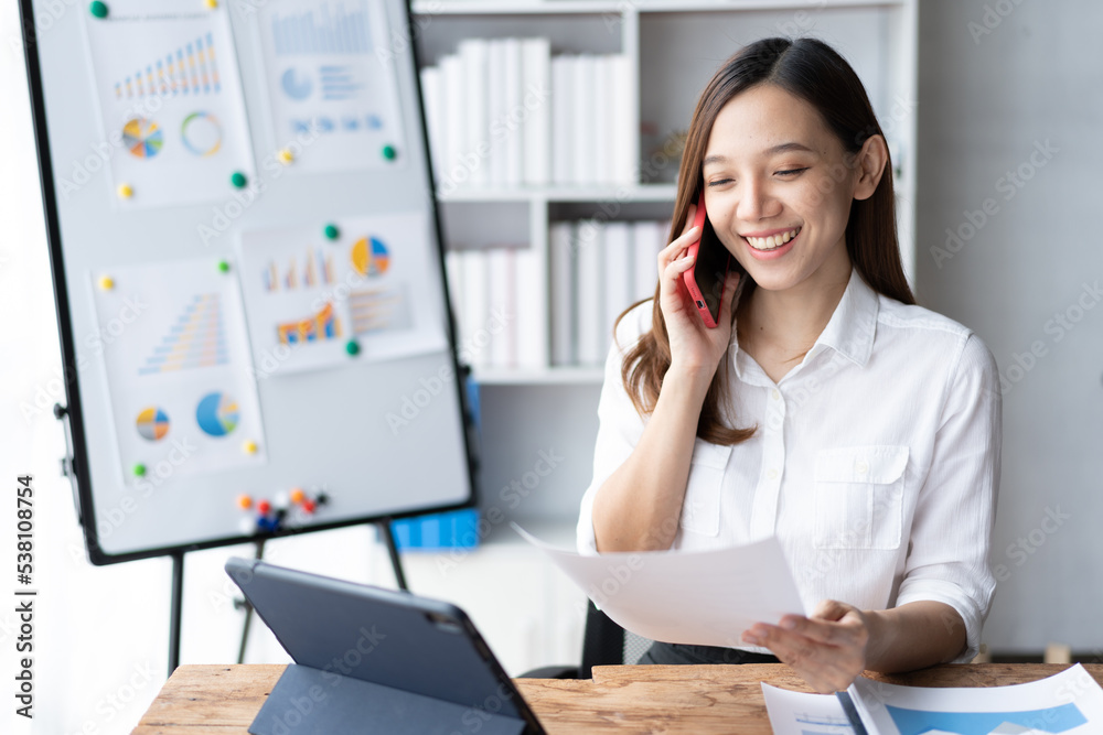 Asian businesswoman in formal suit in office happy and cheerful during using smartphone and working. Asian businesswoman in formal suit in office happy and cheerful during using smartphone and working.