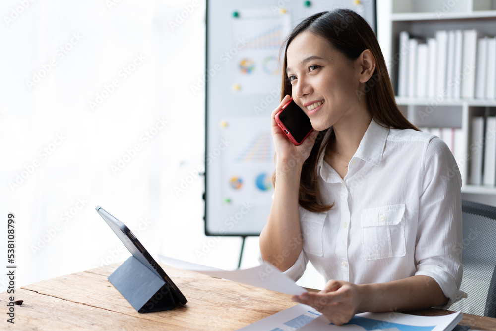 Asian businesswoman in formal suit in office happy and cheerful during using smartphone and working. Asian businesswoman in formal suit in office happy and cheerful during using smartphone and working.
