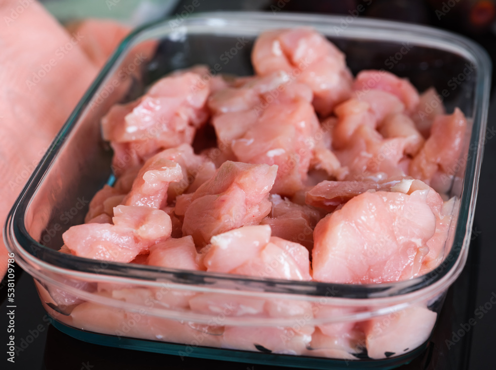 Raw chicken breast slices in glass baking tray Raw chicken breast slices in glass baking tray