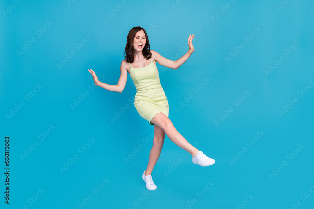 Full body portrait of overjoyed cheerful girl have fun dancing partying isolated on blue color background Full body portrait of overjoyed cheerful girl have fun dancing partying isolated on blue color background