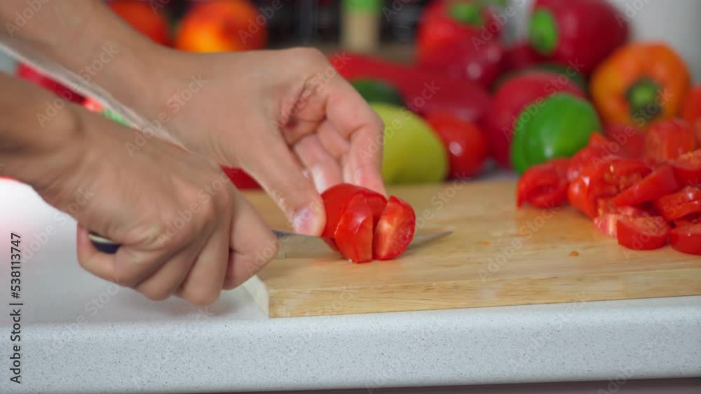 Man cutting tomatoes for salad. Hand cut tomatoes on wood board. Selective focus Man cutting tomatoes for salad. Hand cut tomatoes on wood board. Selective focus