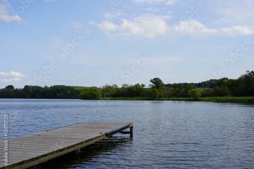 A short boat dock sits on a lake. 