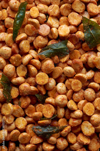 close-up macro view of roasted or fried bengal gram mixed with ground chili peppers, also known as chenna dal or pori or pottu kadalai, indian crispy and spicy snack in full frame, food background photo
