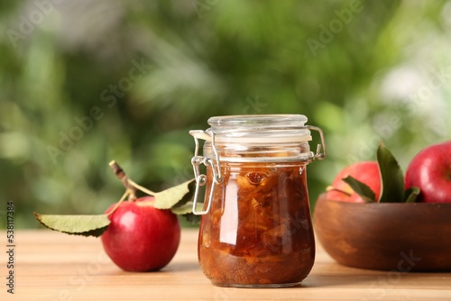 Delicious apple jam and fresh fruits on wooden table