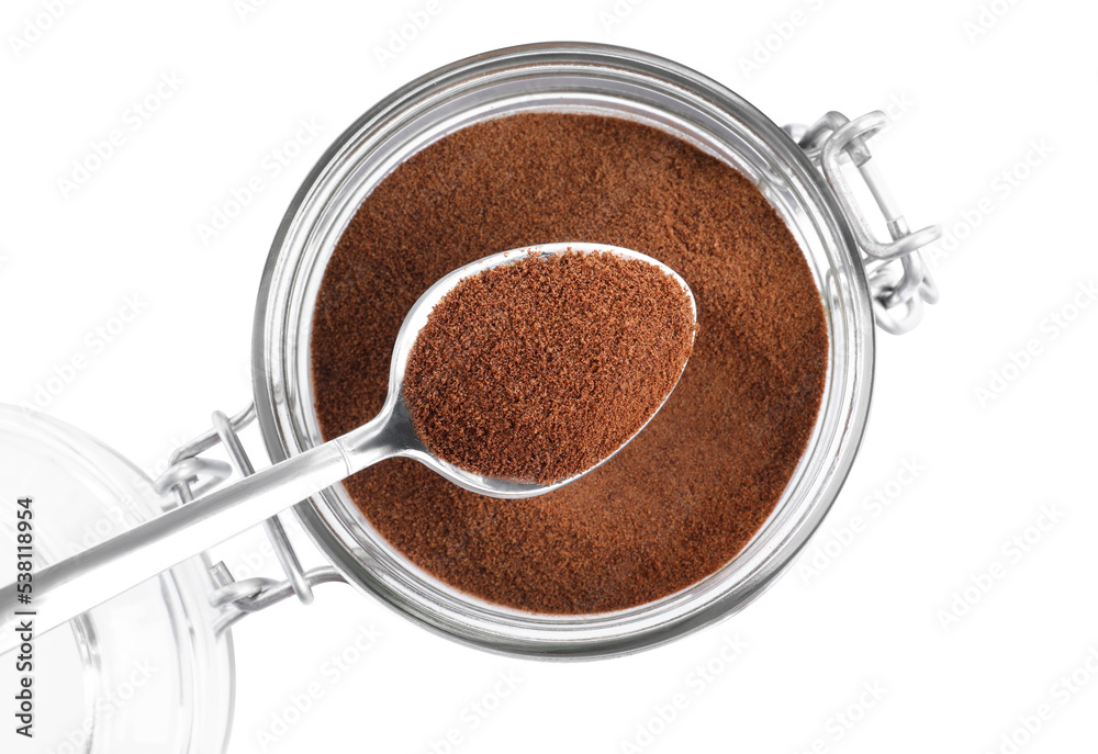Spoon with instant coffee above glass jar isolated on white, top view Spoon with instant coffee above glass jar isolated on white, top view