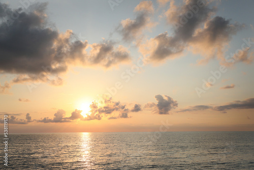Fototapeta Naklejka Na Ścianę i Meble -  Picturesque view of beautiful sea and people parasailing at sunset