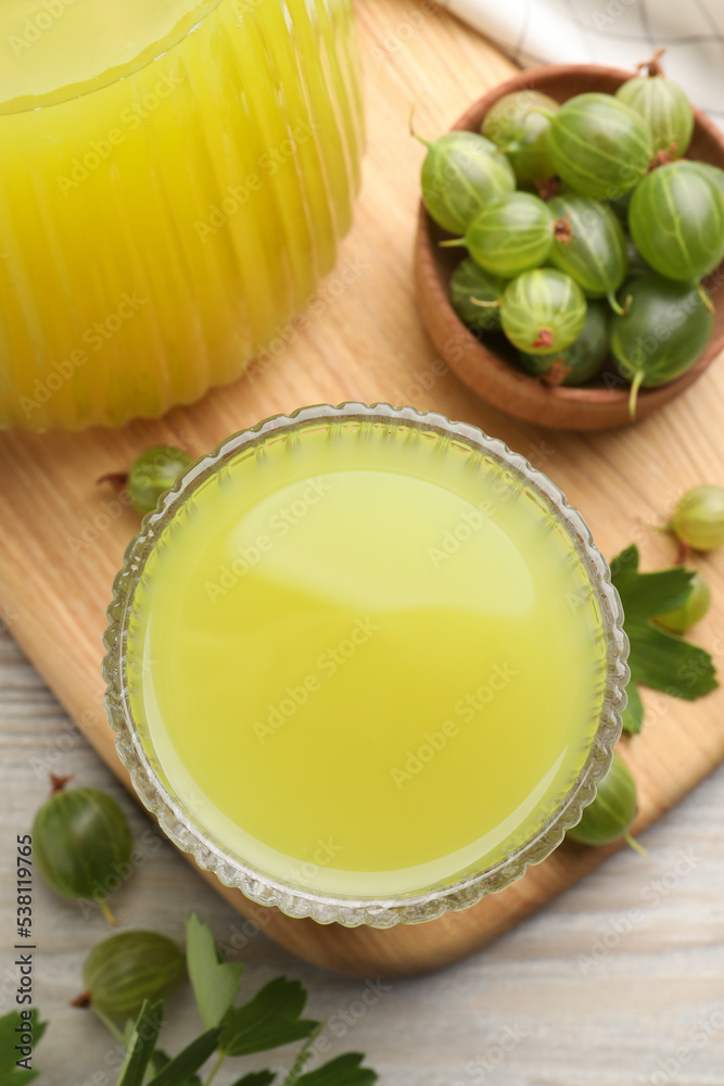 Tasty gooseberry juice and fresh berries on wooden table, closeup Tasty gooseberry juice and fresh berries on wooden table, closeup