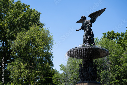 Side view of the Bethesda Fountain (Angel of the Waters) in Central Park, designed by Emma Stebbins (1868), on a sunny summer day photo
