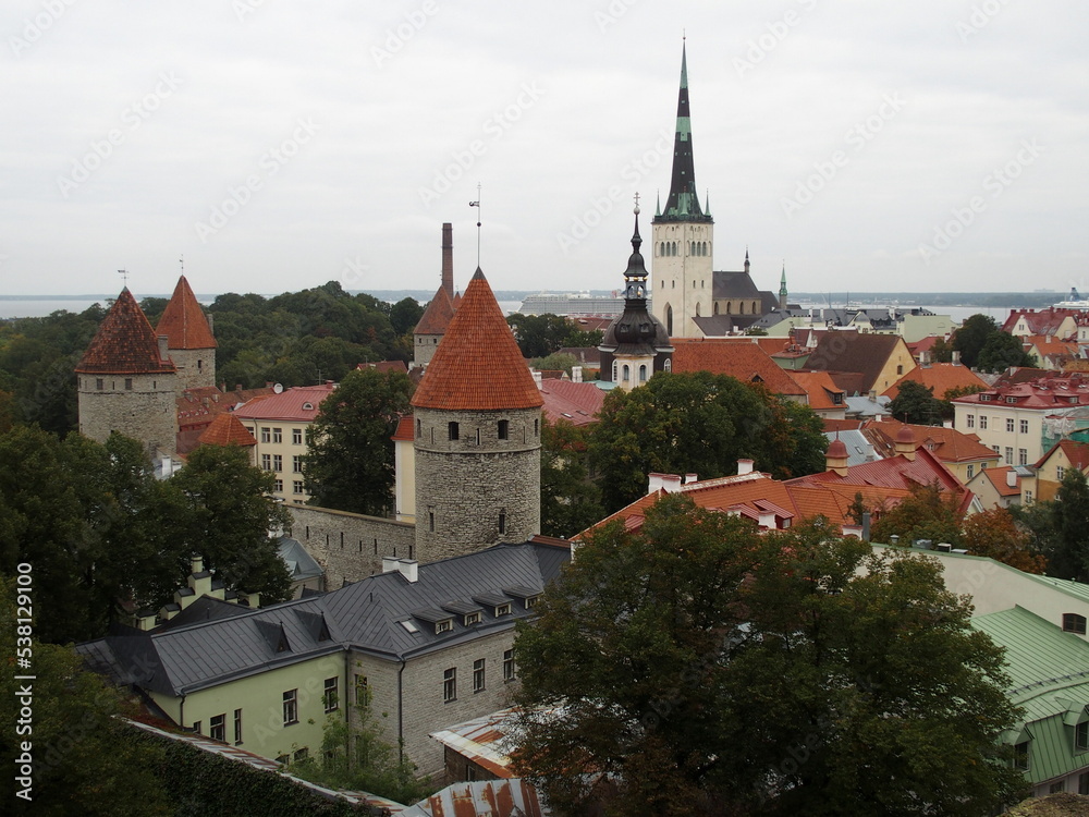 View of Tallinn, Estonia, with the towers of the city wall in the middle and the Tower of Olai Church in the background