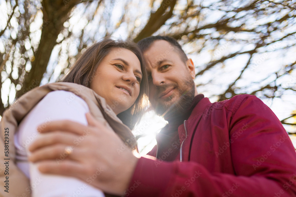 Fototapeta premium portrait of an adult traditional married couple with touching foreheads against the background of an autumn tree