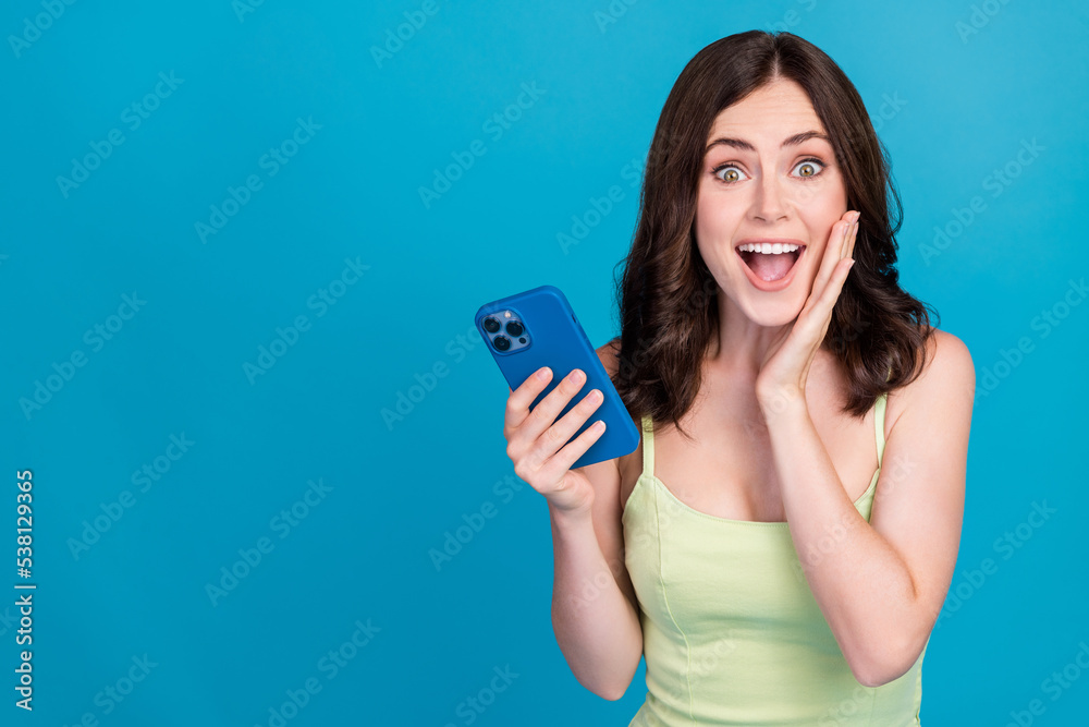 Photo of charming impressed lady wear green outfit arm cheek typing modern gadget empty space isolated blue color background Photo of charming impressed lady wear green outfit arm cheek typing modern gadget empty space isolated blue color background