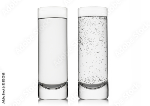 Mineral sparkling and still water in highball glass on white background.