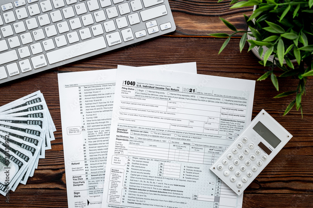 Obraz premium Accountant culculate taxes - US tax form on office table desktop