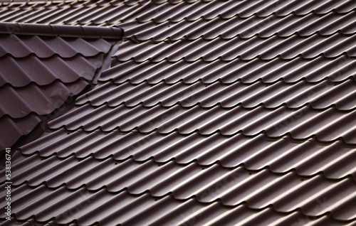 Brown metal tile roof placed on a newly built house. Materials for the construction of the roof.