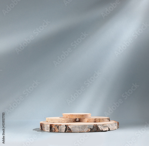 Fototapeta Naklejka Na Ścianę i Meble -  Round wooden slab of cylindrical birch slab on gray background with sunlight Podium. An empty showcase for product presentation