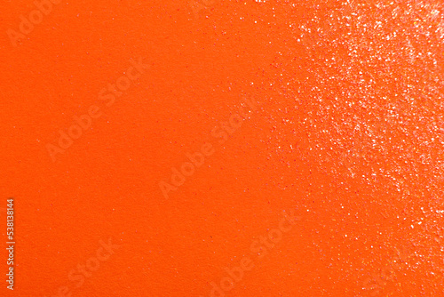 Shiny bright glitter on orange background, flat lay. Space for text