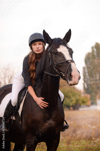 Girl in the field on a horse. They look into the distance. © Елизавета Плотникова