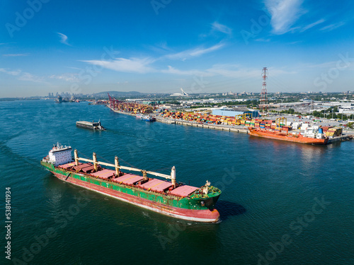 Aerial view of a fully loaded cargo ship leaving the Montreal Port and going downriver on the St.Lawrence River.