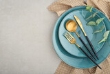 table place setting with blue plates and golden cutlery