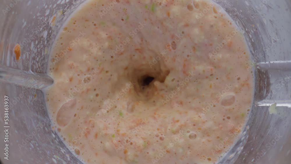 Fruits blend preparing mixer close up top view. Apple carrot blending in blender Fruits blend preparing mixer close up top view. Apple carrot blending in blender