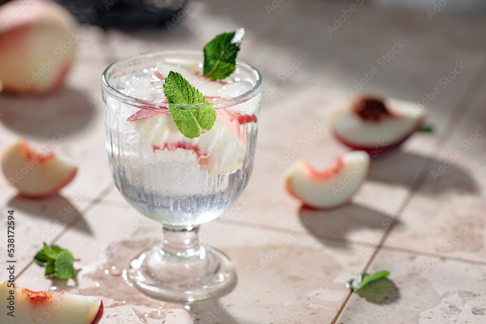 Preparation of a refreshing summer drink from peaches, ice, mint and mineral water Preparation of a refreshing summer drink from peaches, ice, mint and mineral water