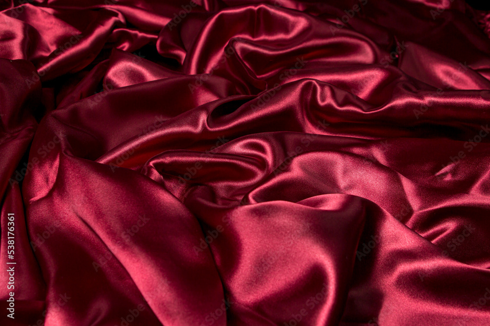 Crumpled red fabric as a background for the image. Texture of red textile material