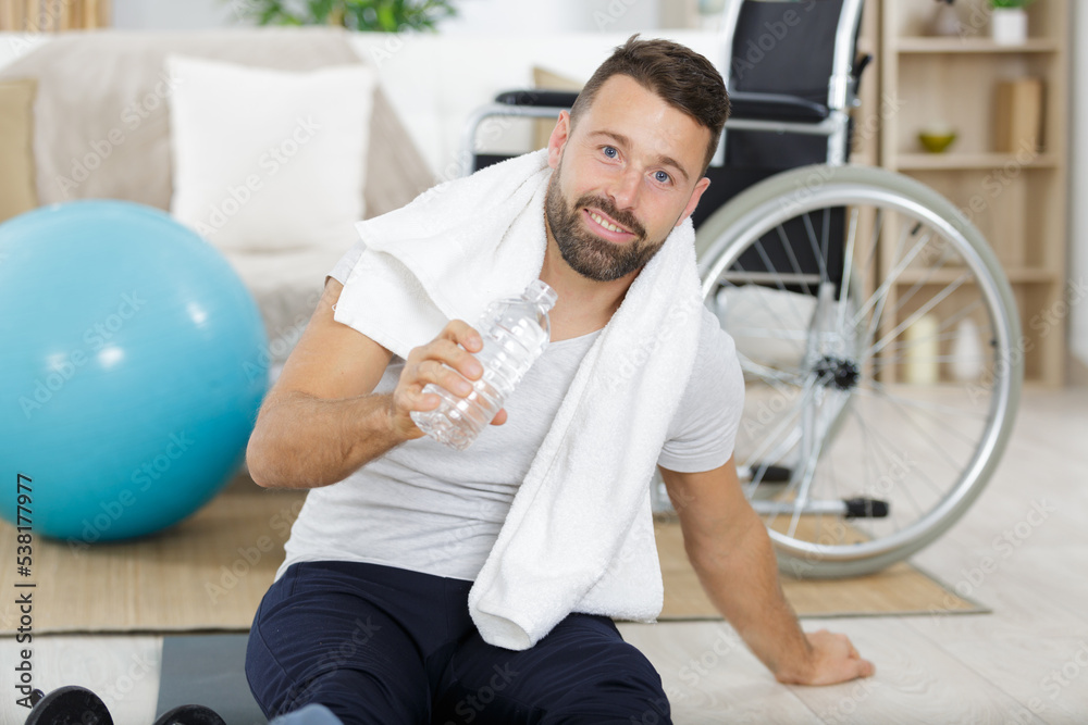 man with bottle of water dumbbell and green towel