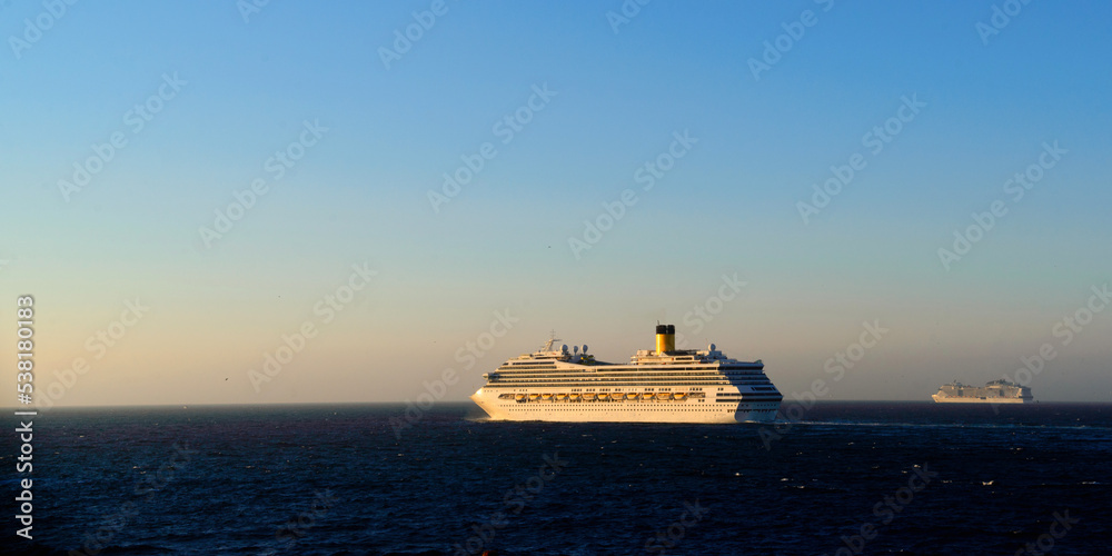 Two cruise ships go out to the ocean in the late evening Two cruise ships go out to the ocean in the late evening