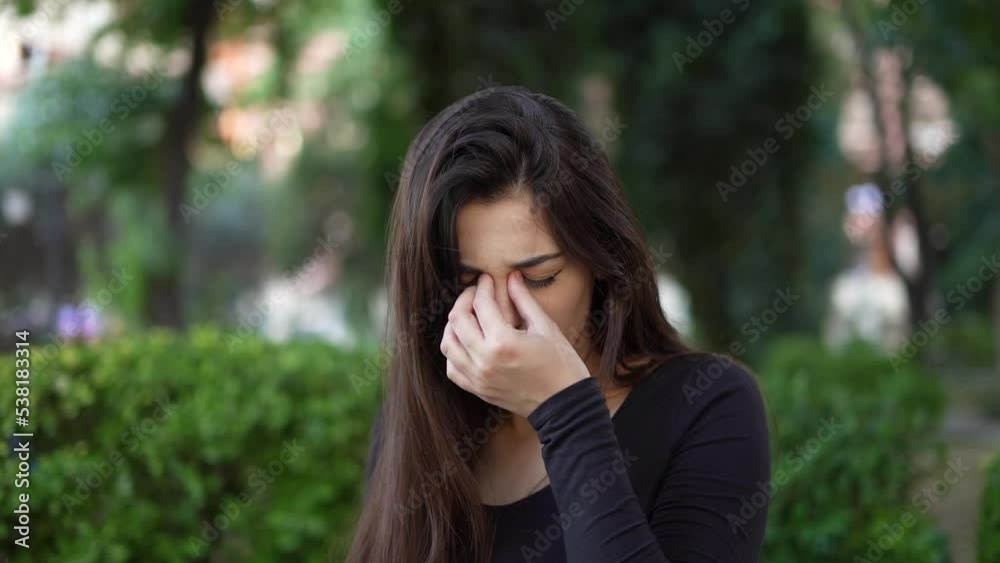 Woman scratching itchy eyes in a park. Woman suffering itching scratching eyes outdoors Woman scratching itchy eyes in a park. Woman suffering itching scratching eyes outdoors