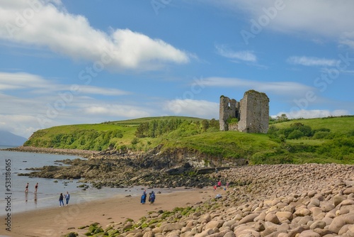 Historical ruined Minard Castle near the beach on a sunny day photo