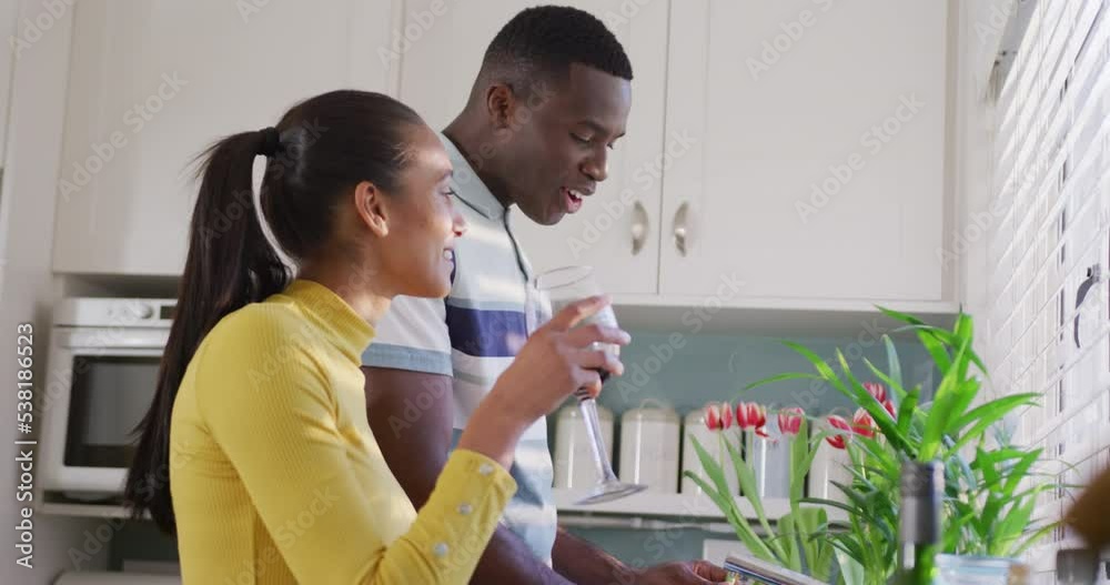 Video of happy diverse couple preparing food together in kitchen and drinking wine Video of happy diverse couple preparing food together in kitchen and drinking wine
