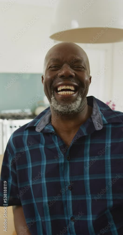 Vertical video portrait of happy senior african american man laughing to camera in kitchen Vertical video portrait of happy senior african american man laughing to camera in kitchen
