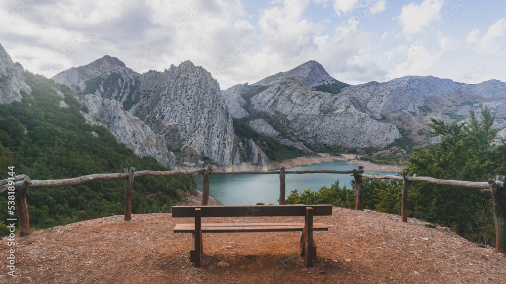 Lonely bench in the middle of the mountains with stunning views of the lake
