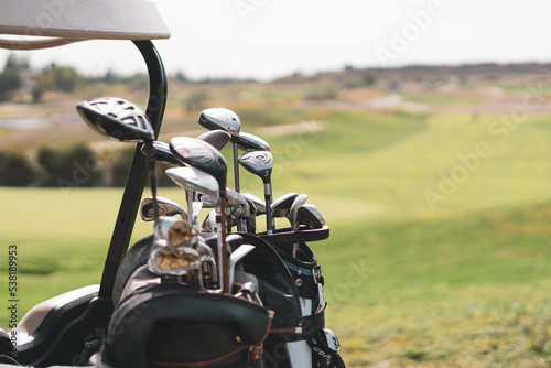 Detalle palos de golf con campo de fondo