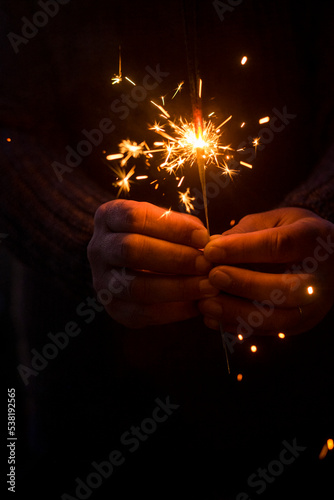 Canvas Print Close up of people and sparkler light in dark black background and copy space